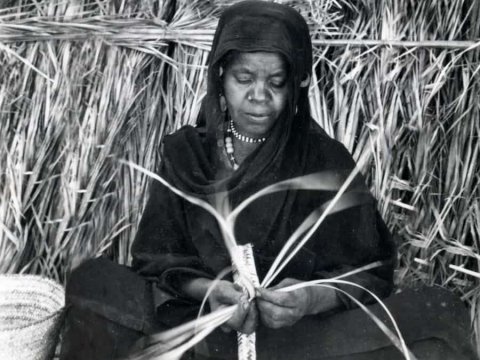 Nubian woman weaving a palm leaf